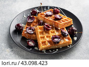 Belgian fluted waffles with fresh cherries and cream on a plate. Soft homemade waffles, sweet dessert with cherries. Стоковое фото, фотограф Глущенко Елена / Фотобанк Лори
