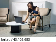 Woman in maternity leave works remotely, with child on his knees. Стоковое фото, фотограф Владимир Григорьев / Фотобанк Лори