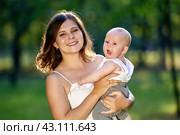 Happy mother is holding yawning little boy in park. Стоковое фото, фотограф Владимир Григорьев / Фотобанк Лори
