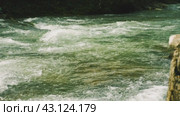 Горная река с прозрачной зелено-голубой водой, которая стремительно течет по камням, образуя белую пену и пузырьки. Вода находится в быстром движении. Медленное движение. Стоковое видео, видеограф Воловодов Владимир / Фотобанк Лори