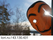 Moscow region, Russia - March 17, 2023: Photography of the Salvador Dali mask peeps in your window. Sunny futuristic day. He looks like smiling man. Sun in his eye. Close up photography. Редакционное фото, фотограф YuryKara / Фотобанк Лори