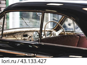 Classic luxury interior of a retro car and a close-up steering wheel. Russia, May 11, 2024. Редакционное фото, фотограф Photojuli / Фотобанк Лори