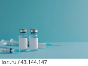 Syringe and glass vial on blue background table. Medical Vials group, needles, ampoules, bottle with medicines or vaccine. Disease treatment. Creative Banner. Anti-aging beauty injections. Vaccination. Стоковое AI-изображение, AI-художник Марина Демидюк / Фотобанк Лори