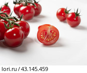 Selective focus. focus on the center tomato cut in half. cherry tomatoes with green tails. Стоковое фото, фотограф Дмитрий Львович Алферов / Фотобанк Лори