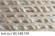 Video of a skein of natural cotton light yarn for hand knitting or crocheting. The texture of cotton threads wound into a ball. Textile background. Flat lay, macro, top view, close-up. Стоковое видео, видеограф Виктория Катьянова / Фотобанк Лори