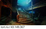 gloomy interior with luxurious staircase of a sunken luxury passenger ship in the rays of light passing through the depths of the ocean. Стоковое AI-изображение, AI-художник Александр Довянский / Фотобанк Лори