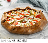 Homemade savory galette with vegetables, wholegrain pie with tomatoes, zucchini. Стоковое фото, фотограф Natalia Gdovskaia / Фотобанк Лори