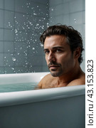 Depressed crazy man mental health in bathtub in bathroom at home looking at camera. Problem person showing human emotions. Concept apathy, anxiety, illness, trouble, creative decline. Copy space. Стоковое AI-изображение, AI-художник Aleksandr Golubev / Фотобанк Лори