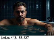 Depressed crazy man mental health in bathtub in bathroom at home looking at camera. Problem person showing human emotions. Concept apathy, anxiety, illness, trouble, creative decline. Copy space. Стоковое AI-изображение, AI-художник Aleksandr Golubev / Фотобанк Лори