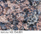 Granite texture. Natural pink granite with a grainy pattern. Stone background. Solid rough surface of rock. Durable construction and decoration material. Close-up. Стоковое фото, фотограф Андрей Степанов / Фотобанк Лори