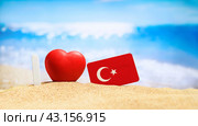 I love Turkey. Flag of Turkey on the beach with a red heart. vacation and travel concept. (2023 год). Стоковое фото, фотограф Никита Бурденков / Фотобанк Лори