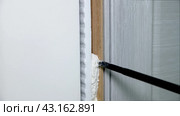 Foaming cracks in the door frame with mounting foam. Construction and repair. Installation and fastening of a wooden frame. Стоковое видео, видеограф Дмитрий Кобзев / Фотобанк Лори