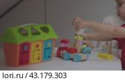 Child playing in colorful educational building blocks educational toys. Boy constructs and creates educational toys endless possibilities of educational developmental toys creativity and learning. Стоковое видео, видеограф Olesia Kondrateva / Фотобанк Лори