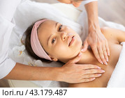 Young woman getting relaxing manual massage of collarbone area and neck. Стоковое фото, фотограф Яков Филимонов / Фотобанк Лори