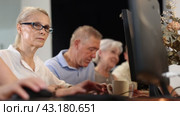 Focused senior woman in glasses attending group computer class, highlighting interest and initiative of older people to embrace digital education. Стоковое видео, видеограф Яков Филимонов / Фотобанк Лори
