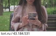 Business woman in the park in the summer writes a message on the phone. Стоковое видео, видеограф Громов Александр / Фотобанк Лори