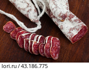 Slicing delicious Spanish smoked sausage fuete. Стоковое фото, фотограф Яков Филимонов / Фотобанк Лори