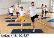 Teen girl with father standing in Eka Pada Pranamasana holding hands. Стоковое фото, фотограф Яков Филимонов / Фотобанк Лори
