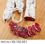 Slicing delicious Spanish smoked sausage fuete. Стоковое фото, фотограф Яков Филимонов / Фотобанк Лори