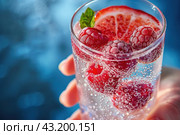Summer cocktail with berries in hand on a blue background. Стоковое AI-изображение, AI-художник Юрий Поздников / Фотобанк Лори