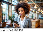 A businesslike dark-skinned African-American woman with curly hair. She is dressed in a casual jacket. In the hands of a smartphone. A businesswoman looks at her mobile phone. Стоковое AI-изображение, AI-художник Photojuli / Фотобанк Лори
