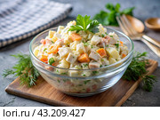 Traditional Russian Olivier salad for a feast on a plate on a wooden countertop. generative AI. Стоковое AI-изображение, AI-художник Photojuli / Фотобанк Лори