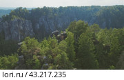 A breathtaking overlook of Bastei Bridge with rock formations surrounded by lush greenery on a clear day. Saxon part of the Elbe Sandstone Mountains in Germany. (2024 год). Стоковое видео, видеограф Igor Tichonow / Фотобанк Лори