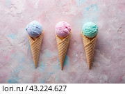Sweet dessert. Ice cream cones with different flavors. Blue, pink, purple ice cream on a background of three pastel colors: blue, pink and purple. Стоковое AI-изображение, AI-художник Photojuli / Фотобанк Лори