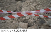 Red white barrier tape trenches. Focus on red and white barrier tape at construction site. Ribbons indicate dug trenches. Стоковое видео, видеограф svetograph / Фотобанк Лори