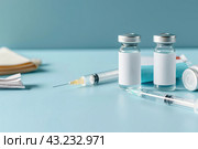 Syringe and glass vial on blue background table. Medical Vials group, needles, ampoules, bottle with medicines or vaccine. Disease treatment. Creative Banner. Anti-aging beauty injections. Vaccination. Стоковое AI-изображение, AI-художник Марина Демидюк / Фотобанк Лори