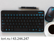 ANGARSK, IRKUTSK REGION, RUSSIA - May 27, 2024: Close-up view of workplace with Logitech keyboard, mouse, cup of morning coffee. Remote work item. Logitech high productivity for creative work. Редакционное фото, фотограф Виктория Катьянова / Фотобанк Лори