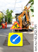 Road work and detour sign on the city road in sunny day. Carrying out construction and repair work in the city (2024 год). Редакционное фото, фотограф FotograFF / Фотобанк Лори