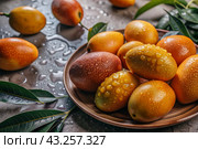 Close-up of fresh mangoes. Delicious berries and fruits are bright yellow in color with drops of water. Vegetarianism. Healthy eating. Fresh fruits on the table. Стоковое AI-изображение, AI-художник Photojuli / Фотобанк Лори