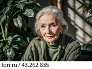 Minimalism. A studio portrait of a stylish, elegant elderly woman, a pensioner of 70 years old, in an interior and clothes of calm tones. The concept of the elderly. Стоковое AI-изображение, AI-художник Photojuli / Фотобанк Лори