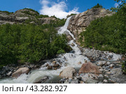 View of the Alibek waterfall formed by the fall of the Jalovchatka River from the Alibek glacier on a sunny summer day, Dombay, Karachay-Cherkessia, Russia. Стоковое фото, фотограф Ula Ulachka / Фотобанк Лори