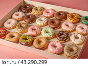 Delicious dessert. A sick box of different donuts with colorful sprinkles on the table. Confectionery products. Стоковое AI-изображение, AI-художник Photojuli / Фотобанк Лори