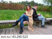 Молодая пара гуляет в лесопарке и пользуются смартфоном. Смартфон в руках. Стоковое фото, фотограф Терехова Марина / Фотобанк Лори