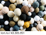 The background is made of balls of wool yarn . Needlework, textiles, knitting. Winter season, small business, handmade clothes. Стоковое AI-изображение, AI-художник Photojuli / Фотобанк Лори