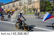 Московский весенний велофестиваль (2024). Парень с белыми крыльями ангела едет на велосипеде./ Moscow spring cycling festival. A guy with white angel wings rides a bicycle. Редакционное фото, фотограф Iva Noel / Фотобанк Лори