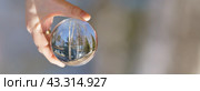 Photography of the beautiful clear crystal ball. Russian tourist resort in focus. Miracle warm view. Human hand holding crystal ball. Photography is full of spring sunlight. Tourist resort. Close up. Стоковое фото, фотограф YuryKara / Фотобанк Лори