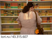 Посетительница книжной лавки на ежегодном книжном фестивале "Красная площадь" в городе Москве, Россия (2024 год). Редакционное фото, фотограф Николай Винокуров / Фотобанк Лори