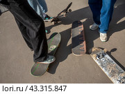 Молодые парни катаются на скейтбордах на улице в городе Москве, Россия (2024 год). Редакционное фото, фотограф Николай Винокуров / Фотобанк Лори
