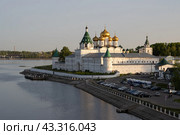 Ипатьевский монастырь, город Кострома, Костромская область, Россия. Вид на Свято-Троицкий Ипатьевский мужской монастырь и набережную реки Костромы. По периметру монастыря каменные стены с башнями. В центре красивая церковь с золотыми куполами — Троицкий собор, построенный в середине 17 века. Историческая и архитектурная достопримечательность. Стоковое фото, фотограф Андрей Степанов / Фотобанк Лори