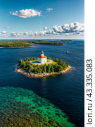 Aerial view landscape of archipelago of islands with lighthouse in Gulf of Finland, skyline at blue sky background. Amazing natural wild scenery view of Scandinavian nature. Copy ad text space. Стоковое AI-изображение, AI-художник Aleksandr Golubev / Фотобанк Лори