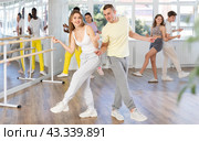 Cheerful young adult couple dancing lindy hop at dance rehearsal. Стоковое фото, фотограф Яков Филимонов / Фотобанк Лори