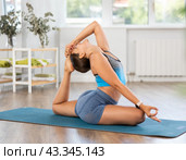 Flexible young woman doing back-bending yoga asana Rajakapotasana. Стоковое фото, фотограф Яков Филимонов / Фотобанк Лори