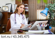 Young woman therapist working with case histories on laptop in office. Стоковое фото, фотограф Яков Филимонов / Фотобанк Лори