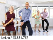 Happy senior woman and man enjoying active boogie-woogie dance in studio. Social dancing concept. Стоковое фото, фотограф Яков Филимонов / Фотобанк Лори