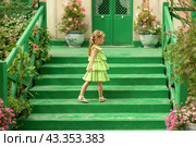 A girl in a green dress in the gardens of Claude Monet in Giverny. Facade of the Monet's house. Стоковое фото, фотограф Irina Kuchugurina/Gaudy / Фотобанк Лори