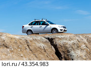 Russian car Lada Granta on on cliff of the canyon (2024 год). Редакционное фото, фотограф Евгений Ткачёв / Фотобанк Лори